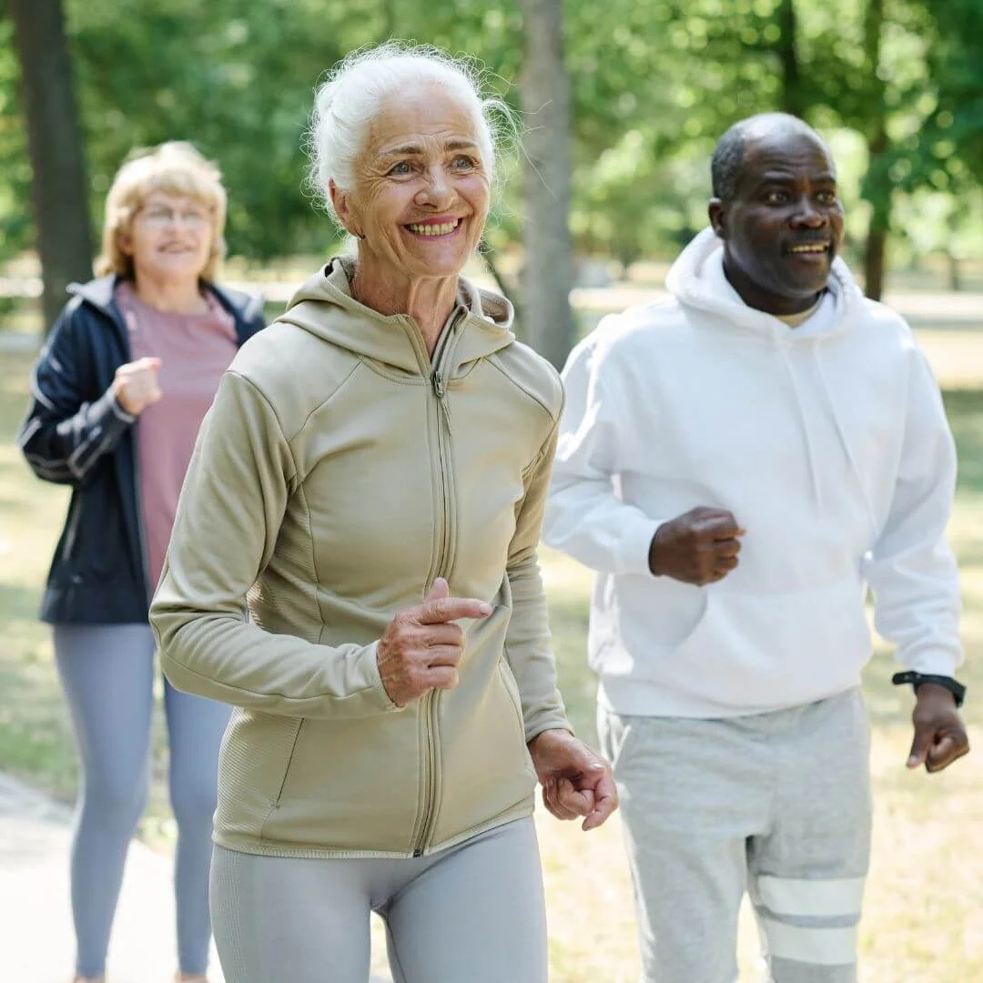 Pessoas idosas ativas e sorridentes correndo em um parque, representando os benefícios da terapia injetável Anti-aging e Longevidade da Infusion Cascavel para um envelhecimento ativo.