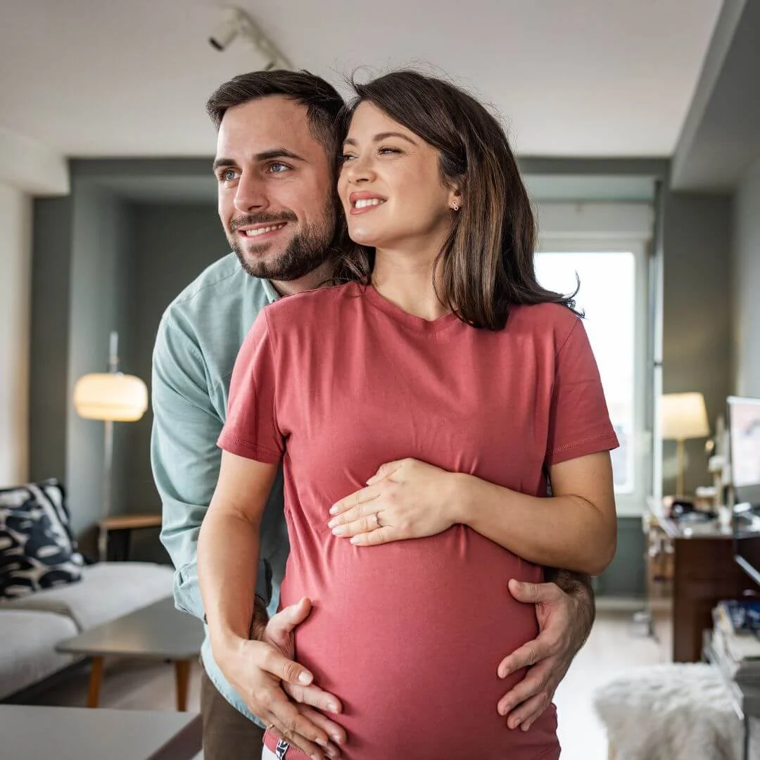 Casal feliz abraçando a barriga de gravidez, representando os benefícios da terapia injetável para Fertilidade e Saúde Hormonal da Infusion Cascavel.